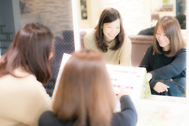 レイヤーカットの入れ方を美容師と相談しているカウンセリング風景